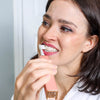 Kvinne med Diamond Smile PAP+ tannblekingspulver pusser tennene