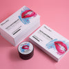 Et Diamond Smile tannblekingssett, blekegel og blekende aktivt kull med rosa bakgrunn