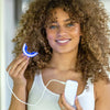 Kvinne med Diamond Smile Power+ Phone Bleaching-munnstykke med LED-skinne i hånden